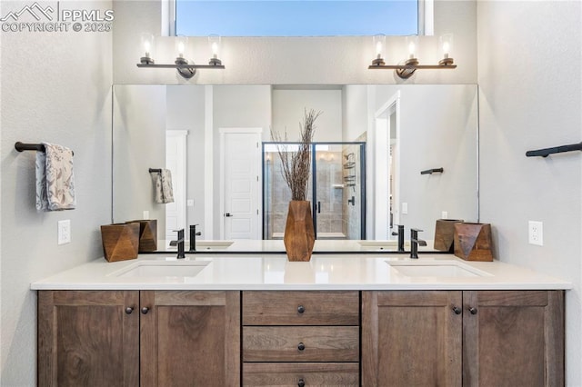 bathroom featuring double vanity, a stall shower, and a sink