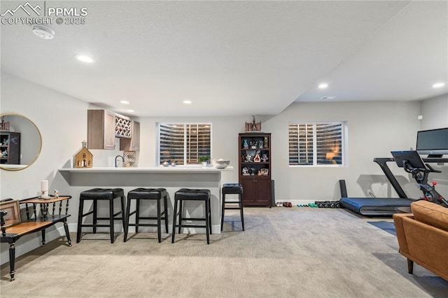 kitchen with light carpet, baseboards, a kitchen breakfast bar, a peninsula, and recessed lighting