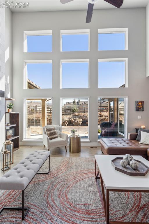 living area featuring a wealth of natural light, a towering ceiling, and wood finished floors