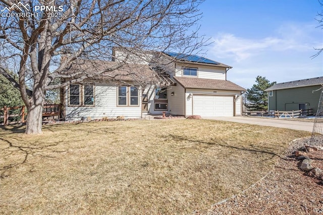 traditional-style house featuring a front yard, driveway, and an attached garage