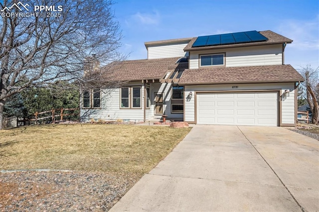 view of front of property featuring solar panels, concrete driveway, a front yard, fence, and a garage