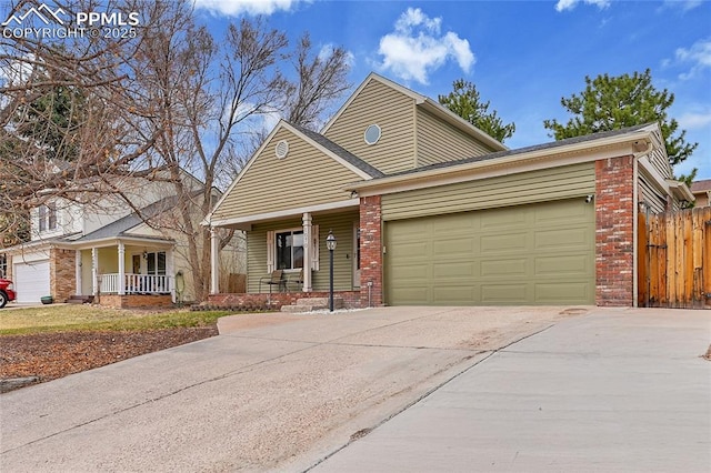view of front of home with fence, driveway, an attached garage, covered porch, and brick siding