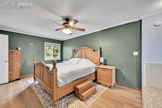 bedroom featuring light wood-style flooring, a textured ceiling, and crown molding