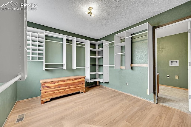 spacious closet with visible vents and wood finished floors