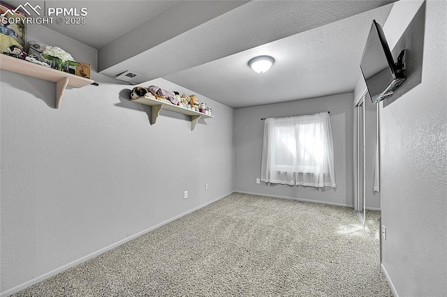 unfurnished bedroom with light carpet, visible vents, a textured ceiling, and baseboards