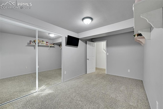 interior space with baseboards, carpet floors, and a textured ceiling