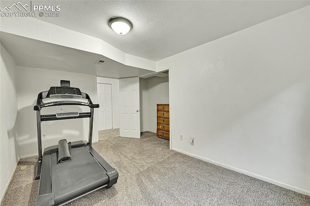 exercise area with visible vents, baseboards, carpet, and a textured ceiling