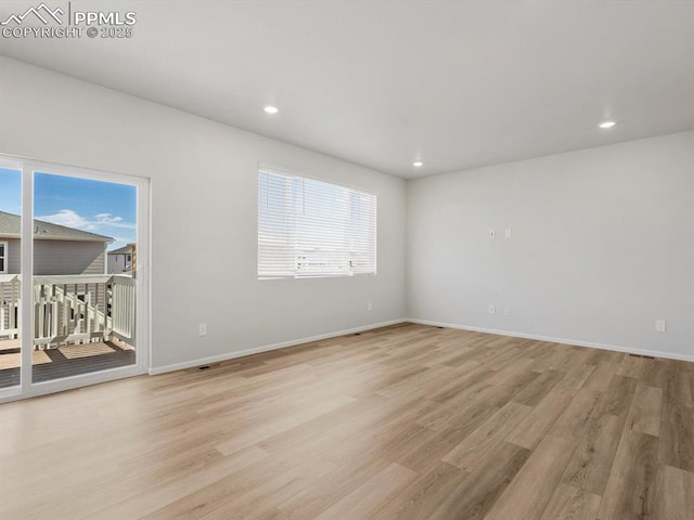empty room with recessed lighting, light wood finished floors, and baseboards