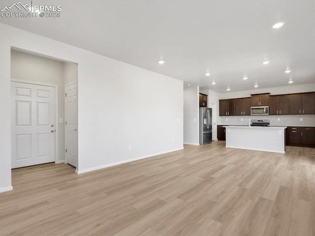 unfurnished living room with light wood-type flooring, baseboards, and recessed lighting