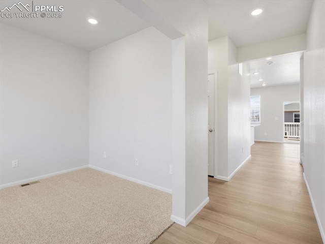spare room featuring baseboards, light wood-style flooring, visible vents, and recessed lighting