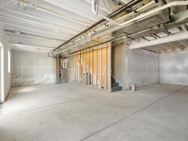 unfinished basement featuring stairway and heating unit