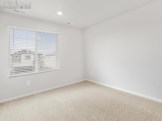 carpeted empty room featuring baseboards and visible vents