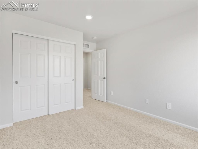 unfurnished bedroom with a closet, baseboards, carpet flooring, visible vents, and recessed lighting