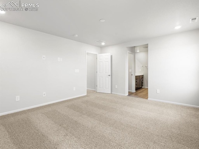 unfurnished bedroom featuring light carpet, visible vents, baseboards, recessed lighting, and connected bathroom