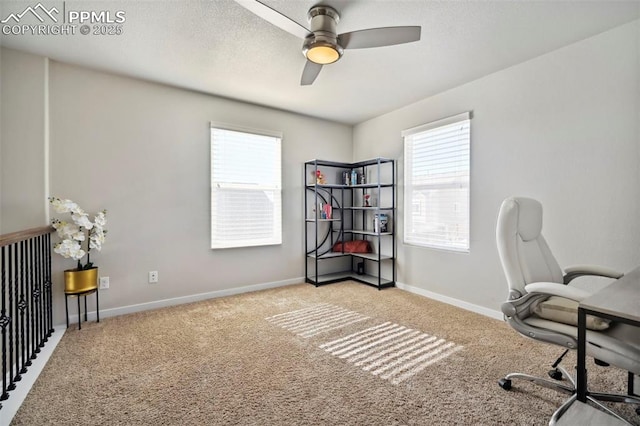 carpeted office space featuring ceiling fan, a textured ceiling, plenty of natural light, and baseboards