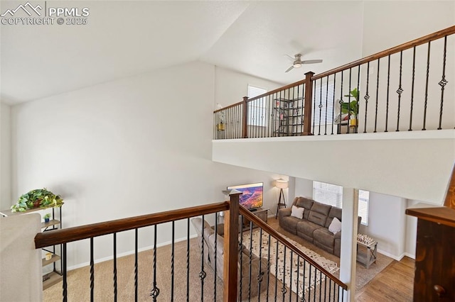 stairs featuring lofted ceiling, ceiling fan, baseboards, and wood finished floors