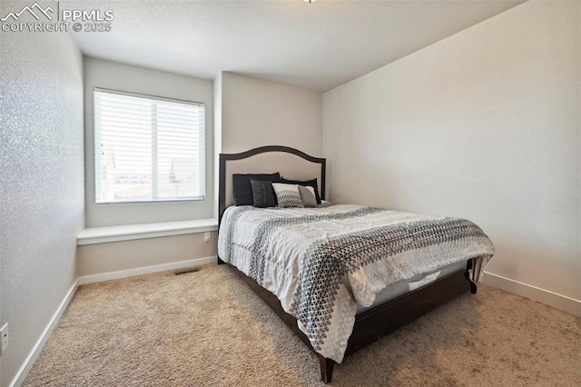 bedroom featuring carpet, visible vents, a textured wall, and baseboards