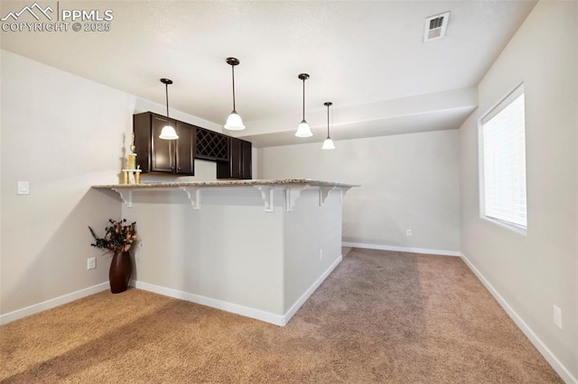 kitchen with light carpet, a breakfast bar, visible vents, and baseboards