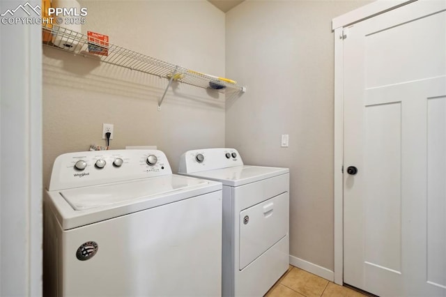 laundry area featuring laundry area, independent washer and dryer, baseboards, and light tile patterned floors