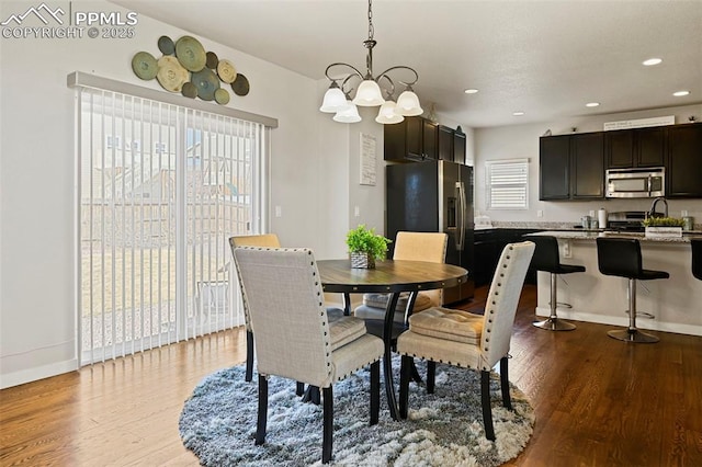 dining area with a notable chandelier, baseboards, wood finished floors, and recessed lighting