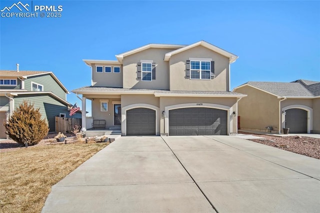 traditional-style home featuring stucco siding, an attached garage, and concrete driveway