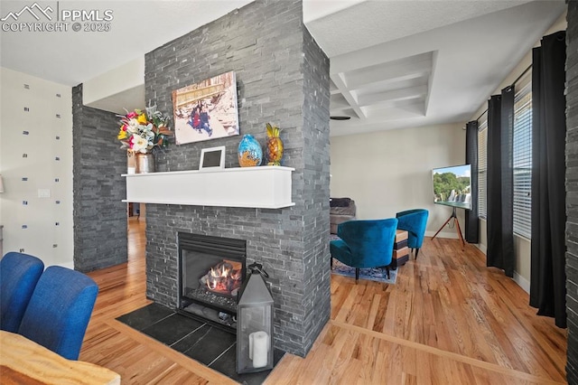 living area featuring wood finished floors, baseboards, coffered ceiling, beam ceiling, and a fireplace