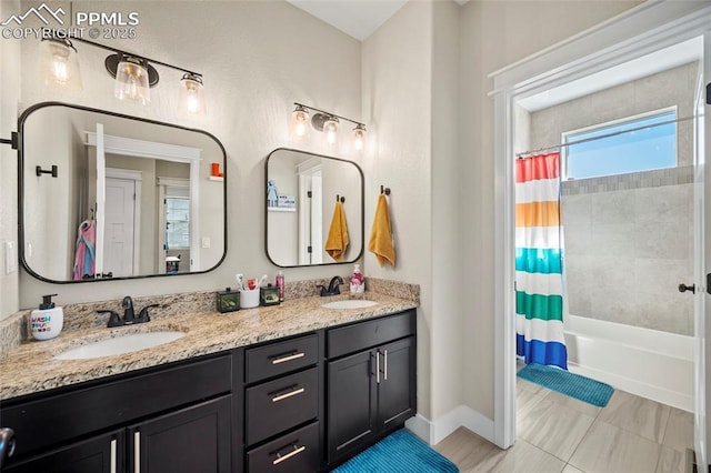 full bathroom with a sink, baseboards, shower / tub combo, and double vanity