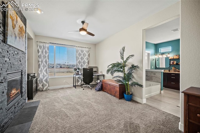 office space with a fireplace, baseboards, ceiling fan, and carpet floors