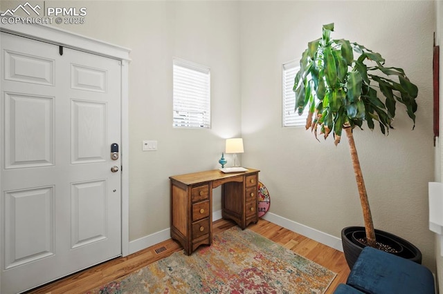 home office with light wood-style flooring and baseboards