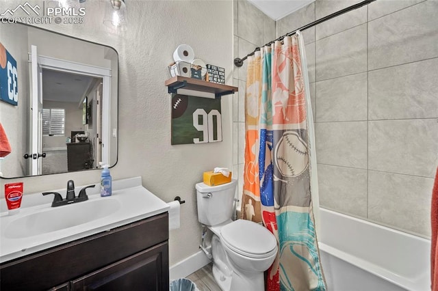 full bath featuring vanity, baseboards, shower / tub combo, toilet, and a textured wall