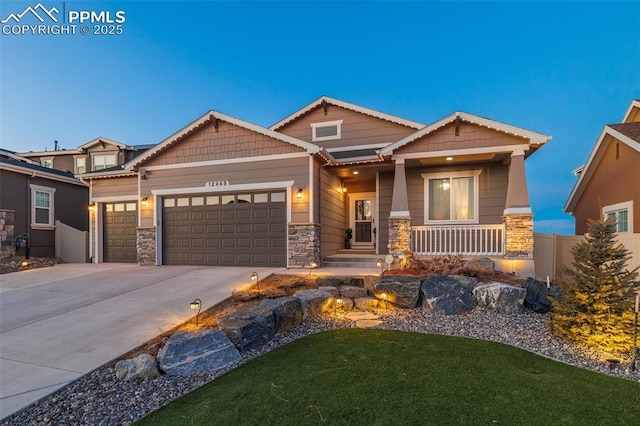 craftsman-style home with stone siding, concrete driveway, and an attached garage