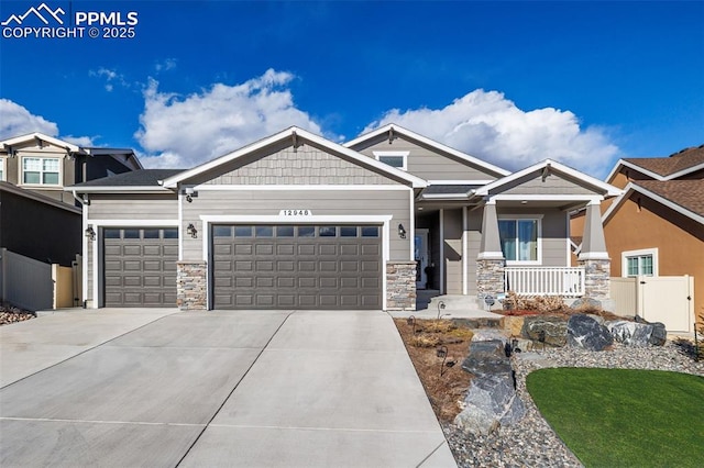 craftsman house with a garage, concrete driveway, covered porch, and fence