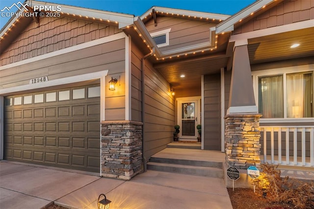 doorway to property featuring stone siding and an attached garage