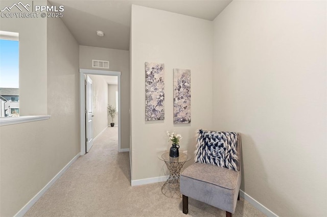 living area with visible vents, carpet flooring, and baseboards