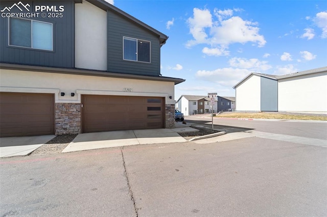 exterior space featuring stone siding and an attached garage