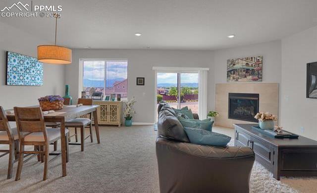 carpeted living room with a glass covered fireplace and recessed lighting