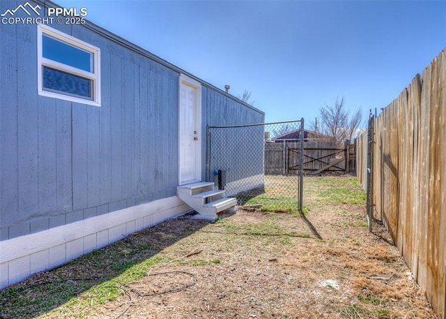 view of yard with entry steps and a fenced backyard