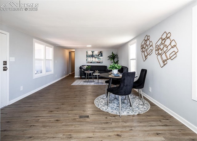 dining area with plenty of natural light, visible vents, baseboards, and wood finished floors