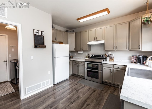 4679 Canyon Wren Ln, Colorado Springs, CO 80916 - kitchen with freestanding refrigerator, range with two ovens, under cabinet range hood, gray cabinetry, and washer and clothes dryer