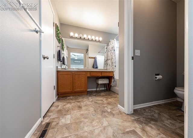 4679 Canyon Wren Ln, Colorado Springs, CO 80916 - full bath with toilet, stone finish flooring, baseboards, vanity, and curtained shower