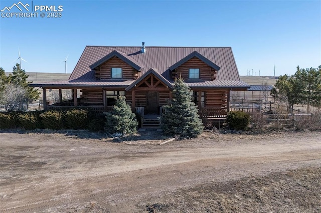 cabin with metal roof, a porch, and log exterior