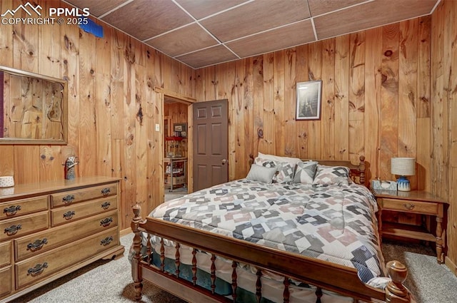 carpeted bedroom with wood walls