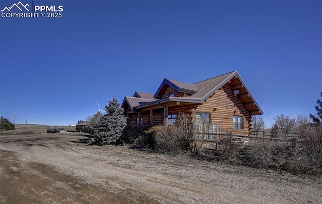 view of front of property with log siding and metal roof