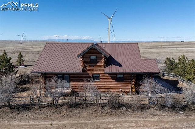 view of front of home with fence, metal roof, and log exterior