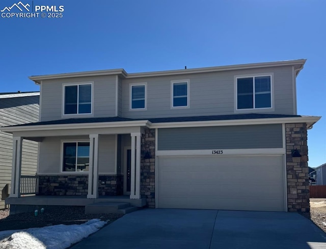 view of front of home with covered porch, stone siding, driveway, and a garage