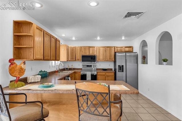 kitchen featuring light tile patterned flooring, recessed lighting, a sink, visible vents, and appliances with stainless steel finishes