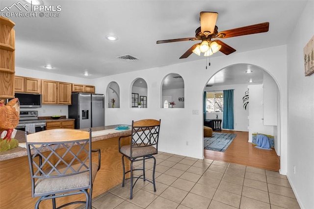 kitchen featuring light tile patterned floors, visible vents, ceiling fan, appliances with stainless steel finishes, and open shelves