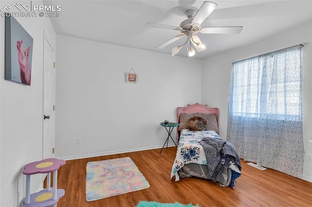 bedroom with ceiling fan, wood finished floors, visible vents, and baseboards