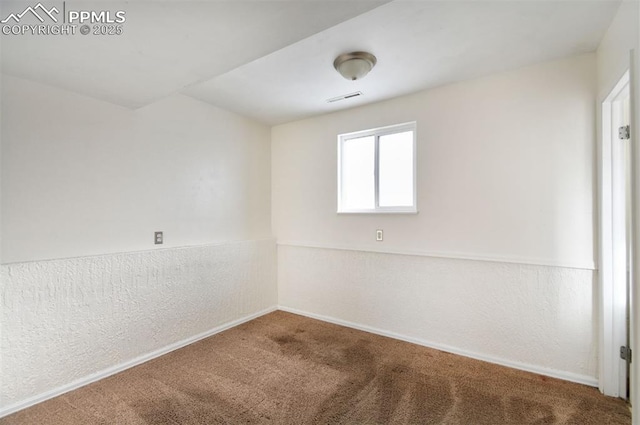 carpeted spare room featuring visible vents