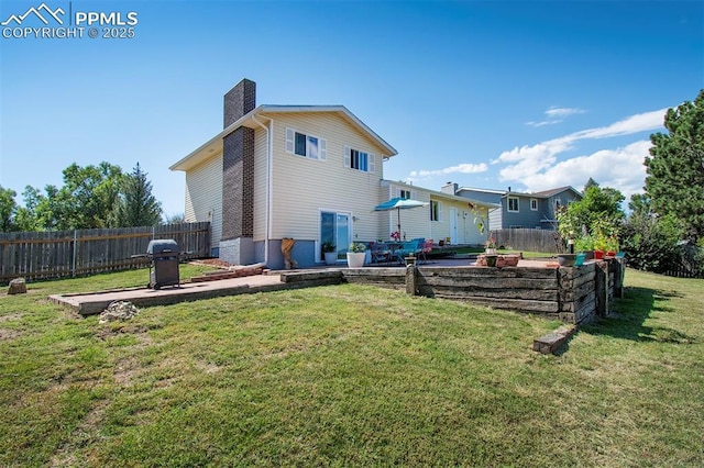 back of property featuring a yard, a chimney, a patio area, a fenced backyard, and a fire pit